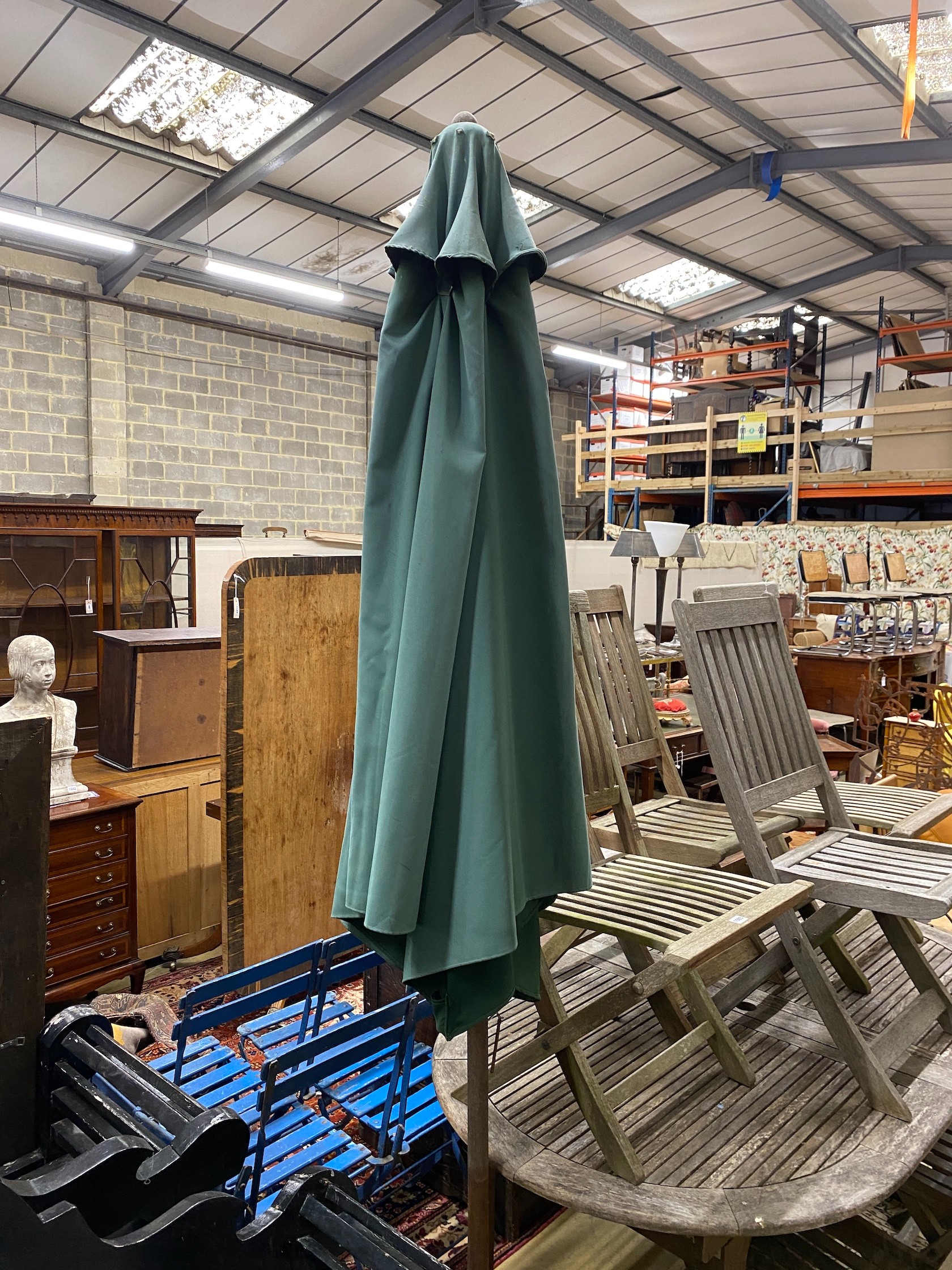 A weathered teak extending garden table, length 170cm, width 100cm, height 74cm parasol with cast metal base and six folding chairs (four and two)